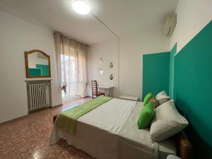 a bedroom with a large bed with a green headboard at VERONA CENTRO MARIA's HOUSE in Verona