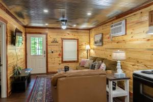 - un salon avec des murs en bois et un canapé dans l'établissement Halfmoon Hideaway-Cozy 2 bdr cabin Mena AR, à Mena