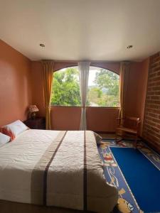 a bedroom with a bed and a large window at Casa de campo Guano Ecuador in Riobamba