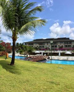 a resort with a palm tree and a swimming pool at Flat no Beach Class Muro Alto in Porto De Galinhas +22 photos
