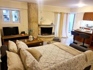 Filoxenia Luxury Home Patras في باترا: غرفة معيشة مع أريكة ومدفأة