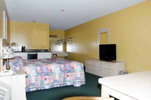 a hotel room with a bed and a tv at Key West Inn - Childersburg in Childersburg