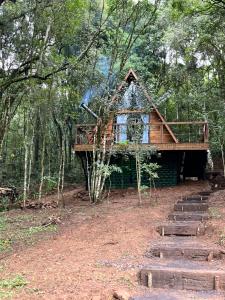 a log cabin in the woods with a deck at Chalé da Roça - Garibaldi in Garibaldi