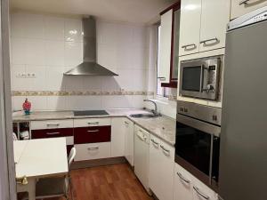 a kitchen with white cabinets and a stove top oven at Piso céntrico in Medina del Campo