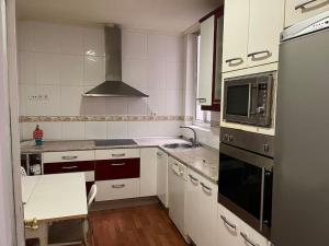 a kitchen with white cabinets and a stove top oven at Piso céntrico in Medina del Campo
