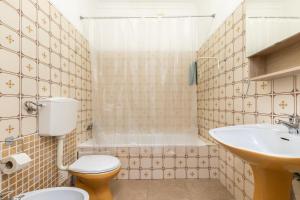 La salle de bains est pourvue de toilettes, d'un lavabo et d'une baignoire. dans l'établissement Porta Nova Guesthouse by R-Tex, à Tavira