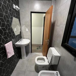 a bathroom with a toilet and a sink at Moderno departamento frente a ciudad cultural II in San Salvador de Jujuy