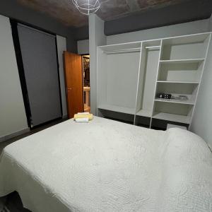a bedroom with a white bed and a window at Moderno departamento frente a ciudad cultural II in San Salvador de Jujuy
