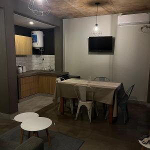 a dining room with a table and chairs and a kitchen at Moderno departamento frente a ciudad cultural II in San Salvador de Jujuy