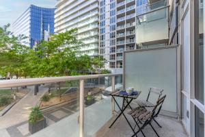 a balcony with a table and chairs on a building at Luxury 2BR Apt-CN View-Free Parking-Roof Top Pool in Toronto