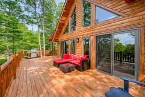 una terraza de madera con muebles de color rojo en una casa en Deep Creek Mountain Retreat, en McHenry