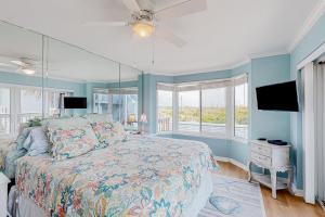 a bedroom with a bed and a tv and windows at Ponce Inlet Villa in Ponce Inlet