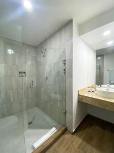 Hotel Pacific Blue Mazatlan في مازاتلان: حمام مع دش ومغسلة