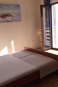 Bett in einem Zimmer mit einem großen Fenster in der Unterkunft Apartments and rooms with parking space Sobra, Mljet - 18465 in Babino Polje