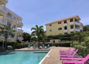 Blue Bay的住宿－# Blue Bay Beach - Ocean View Apartments #，一座带躺椅的游泳池和一座建筑