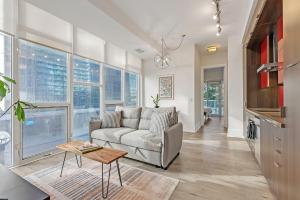 a living room with a couch and a table at Luxury 2BR Apt-CN View-Free Parking-Roof Top Pool in Toronto