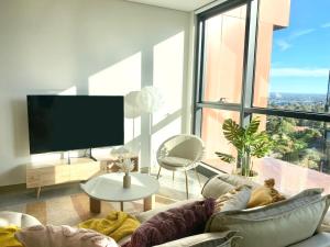 een woonkamer met een bank en een groot raam bij Central Apartment St Leonards in Sydney