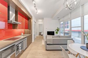 a kitchen and living room with a couch and a table at Luxury 2BR Apt-CN View-Free Parking-Roof Top Pool in Toronto