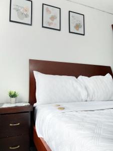 波哥大的住宿－Royal Rooms，一间卧室配有一张带木制床头板和一张桌子的床。