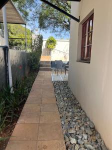 a patio with a stone walkway next to a house at The Green Room on Leo Epstein in Johannesburg