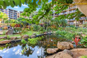 a garden with a pond in front of a building at Kaanapali Shores 640 in Kahana