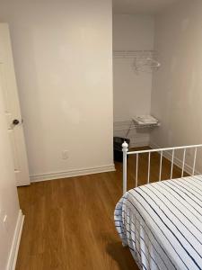 a bedroom with a bed and a wooden floor at Quad Room with En Suite Bathroom 536A in Toronto