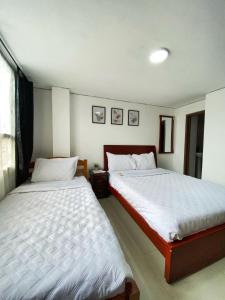 波哥大的住宿－Royal Rooms，一间卧室设有两张床和窗户。