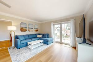 sala de estar con sofá azul y TV en Poulsbo Haven Retreat, en Poulsbo