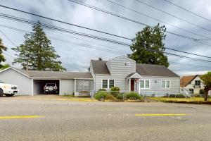 una casa blanca con un coche aparcado en la entrada en Poulsbo Haven Retreat, en Poulsbo