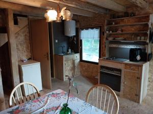 La cuisine est équipée d'une table, d'une cuisinière et d'un réfrigérateur. dans l'établissement Cowboy House at Ranch Lambergar, 