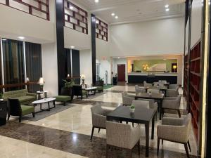 a restaurant with tables and chairs in a lobby at Holiday Inn Mayaguez & Tropical Casino, an IHG Hotel in Mayaguez