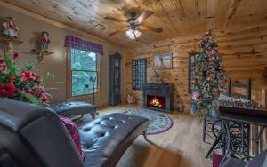 Roost on the Ridge في إليجاي: غرفة معيشة مع موقد وشجرة عيد الميلاد