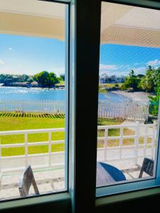 a window with a view of a body of water at SeaLaVie Apartments - Grenada in Saint Georgeʼs
