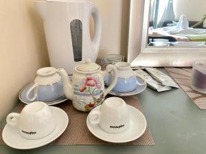 a table with three tea cups and saucers on it at Lovely double room with private bathroom and Double room with shared toilet & PARKING FREE in Edinburgh