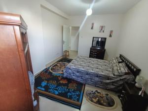 a small bedroom with a bed and a kitchen at BEJAIA Location Appartement et Voiture in Bejaïa