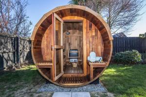 uma sauna circular de madeira com uma televisão num quintal em Allen Street - Studio & Optional Private Sauna em Methven