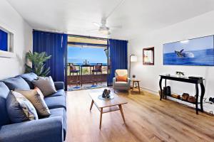 sala de estar con sofá azul y mesa en Kahana Villa F407 en Kahana