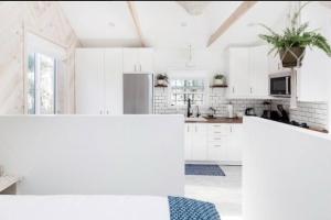 a white kitchen with white cabinets and white appliances at Venice beach from stunning Casita Indigo studio in Los Angeles