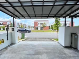 un garage aperto con un'auto parcheggiata in un parcheggio di RAPID Pelali Pengerang Homestay a Pengerang