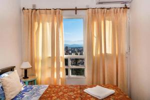 a bedroom with a window with a view of a city at Balcones de Salta in Salta +67 photos