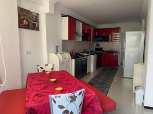 eine Küche mit einem Tisch und einem roten Tischtuch in der Unterkunft ANTALYA BELEK HOLİDAY ViLLAS in Belek