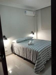 um quarto com uma cama com dois bichos de peluche em Apartamento setor Bueno em Goiânia