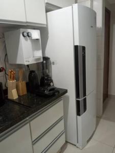 a kitchen with a white refrigerator in a kitchen at Apartamento setor Bueno in Goiânia