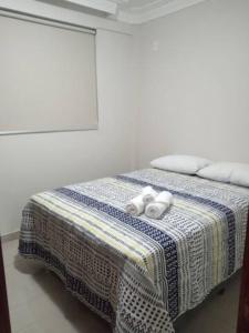 a bedroom with a bed with two towels on it at Apartamento setor Bueno in Goiânia