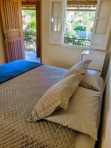 a bedroom with a bed with a pillow and a window at Villa Terracotta in Miguel Pereira