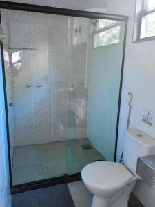 a bathroom with a toilet and a glass shower at Villa Terracotta in Miguel Pereira