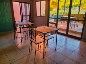 a dining room with tables and chairs and a patio at Villa Terracotta in Miguel Pereira