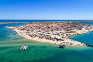 an aerial view of a beach with boats in the water at The Islands in Faro