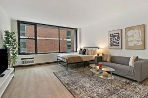 a living room with a couch and a table and a window at Simple and Cozy Studio Apartment- Chestnut 04D in Chicago