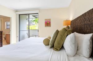 a bedroom with a white bed with white pillows at Kapalua Golf Villa 18V4 in Kahana